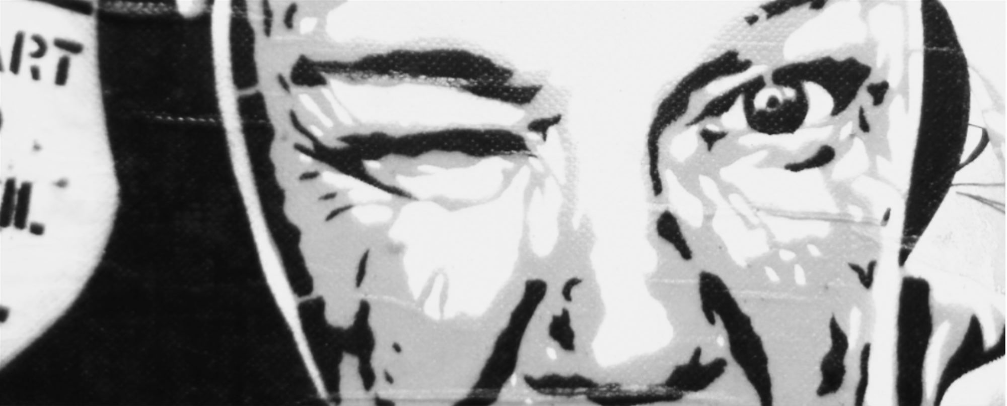 Black-and-white street stencil of a face, one eye open and staring.